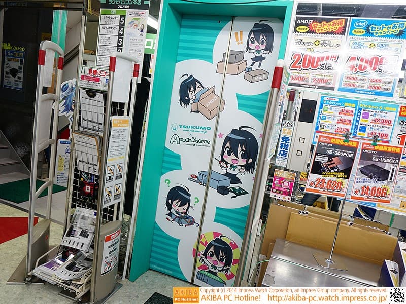 A TSUKUMO storefront pillar in Akihabara wrapped in Amada Kokoro chibi artwork, photographed in 2014
